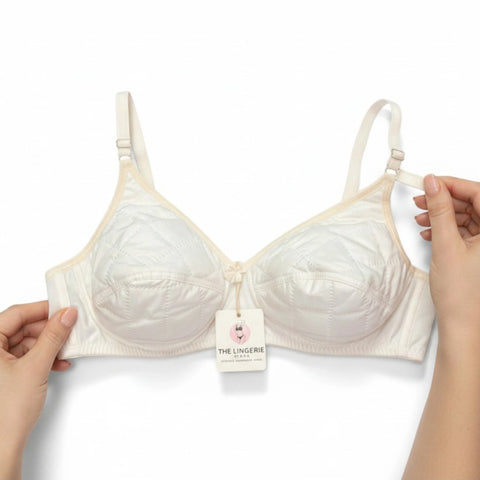 Back view of the off-white quilted bra showing the adjustable hook-and-eye closure and wide comfortable band.